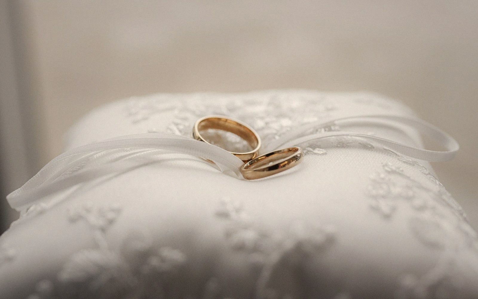 A plain gold band on a worn ring cushion